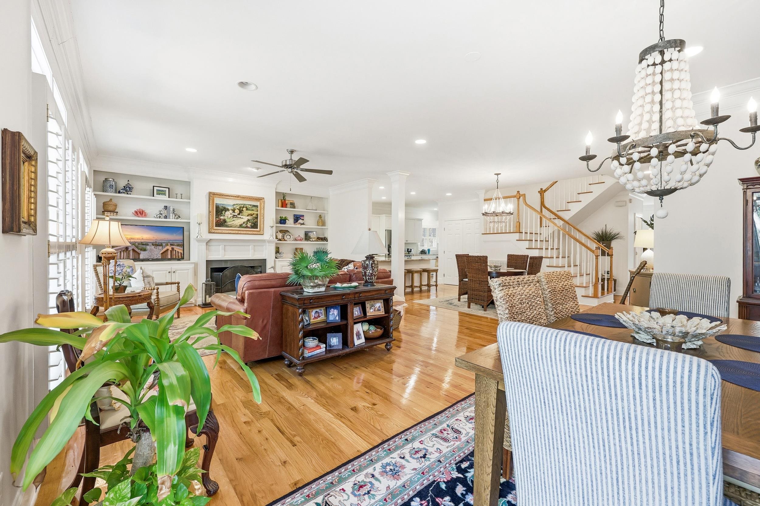 213 Old Carriage Loop Georgetown, SC 29440 - Photo 12 of 40 Dining room with stairway, a fireplace, hardwood / wood-style floors, a chandelier, and built in shelves
