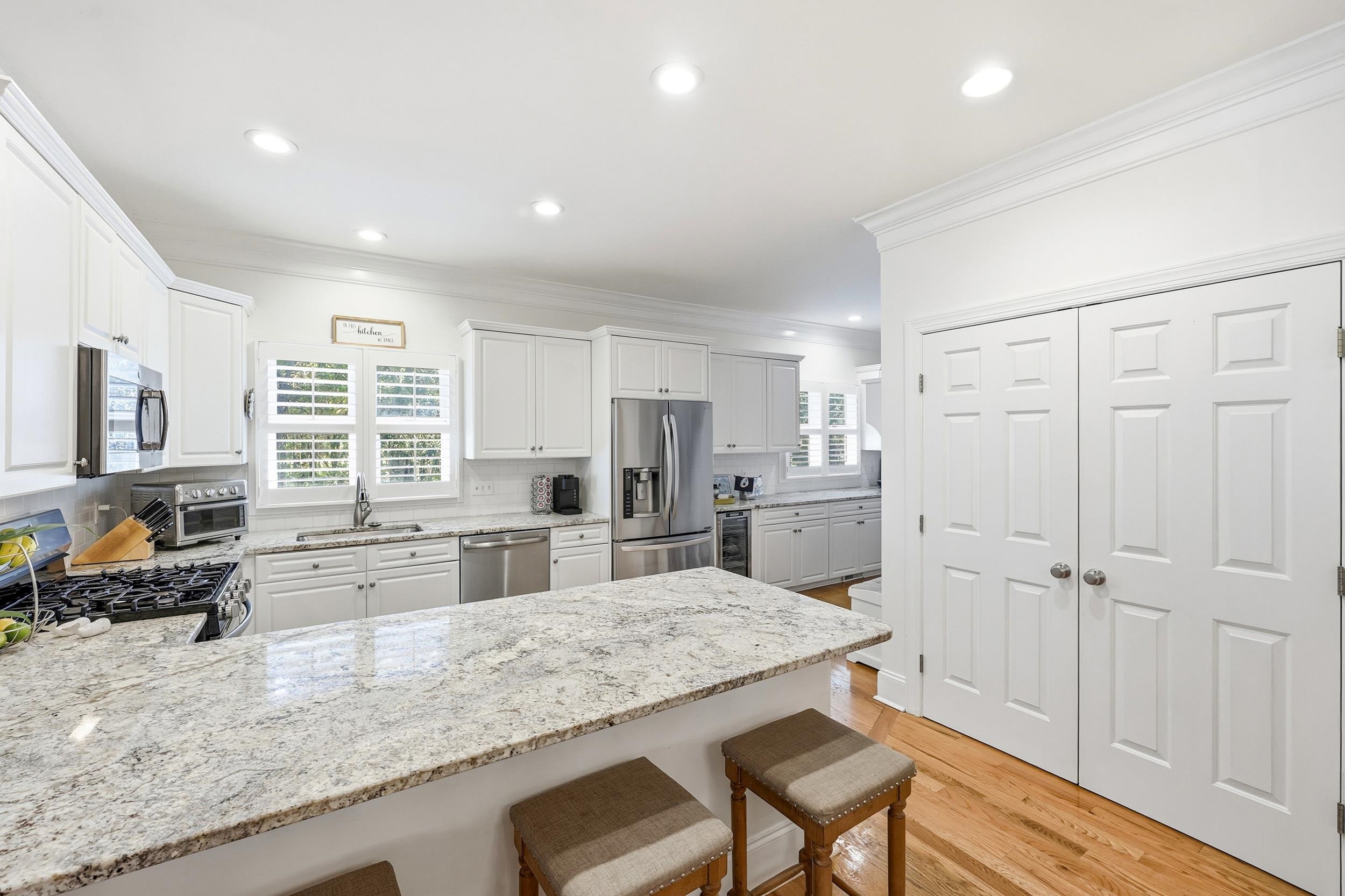 213 Old Carriage Loop Georgetown, SC 29440 - Photo 13 of 40 Kitchen featuring light stone counters, a breakfast bar, stainless steel appliances, a peninsula, and white cabinetry