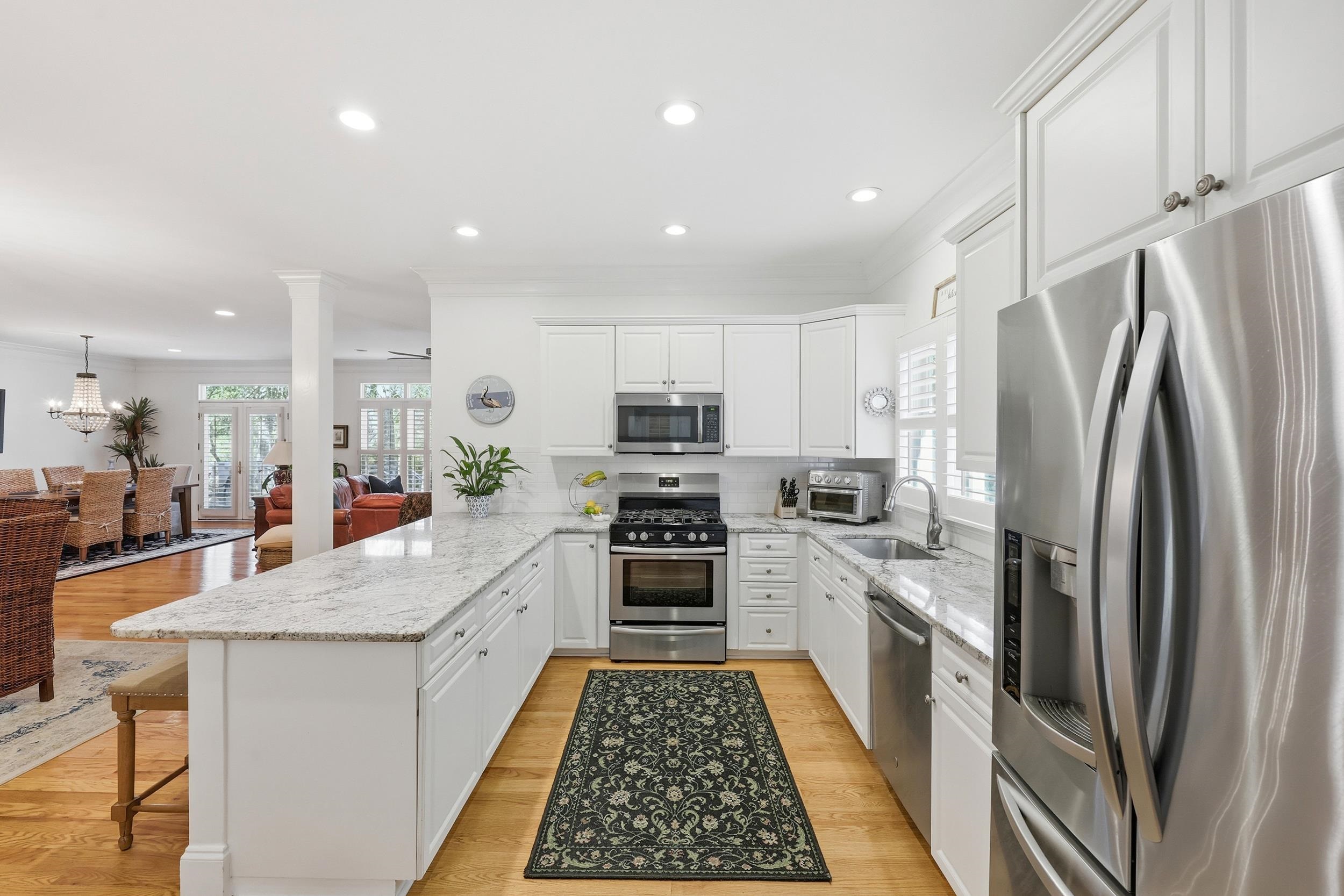 213 Old Carriage Loop Georgetown, SC 29440 - Photo 15 of 40 Kitchen with appliances with stainless steel finishes, light stone counters, a peninsula, white cabinetry, and ornamental molding