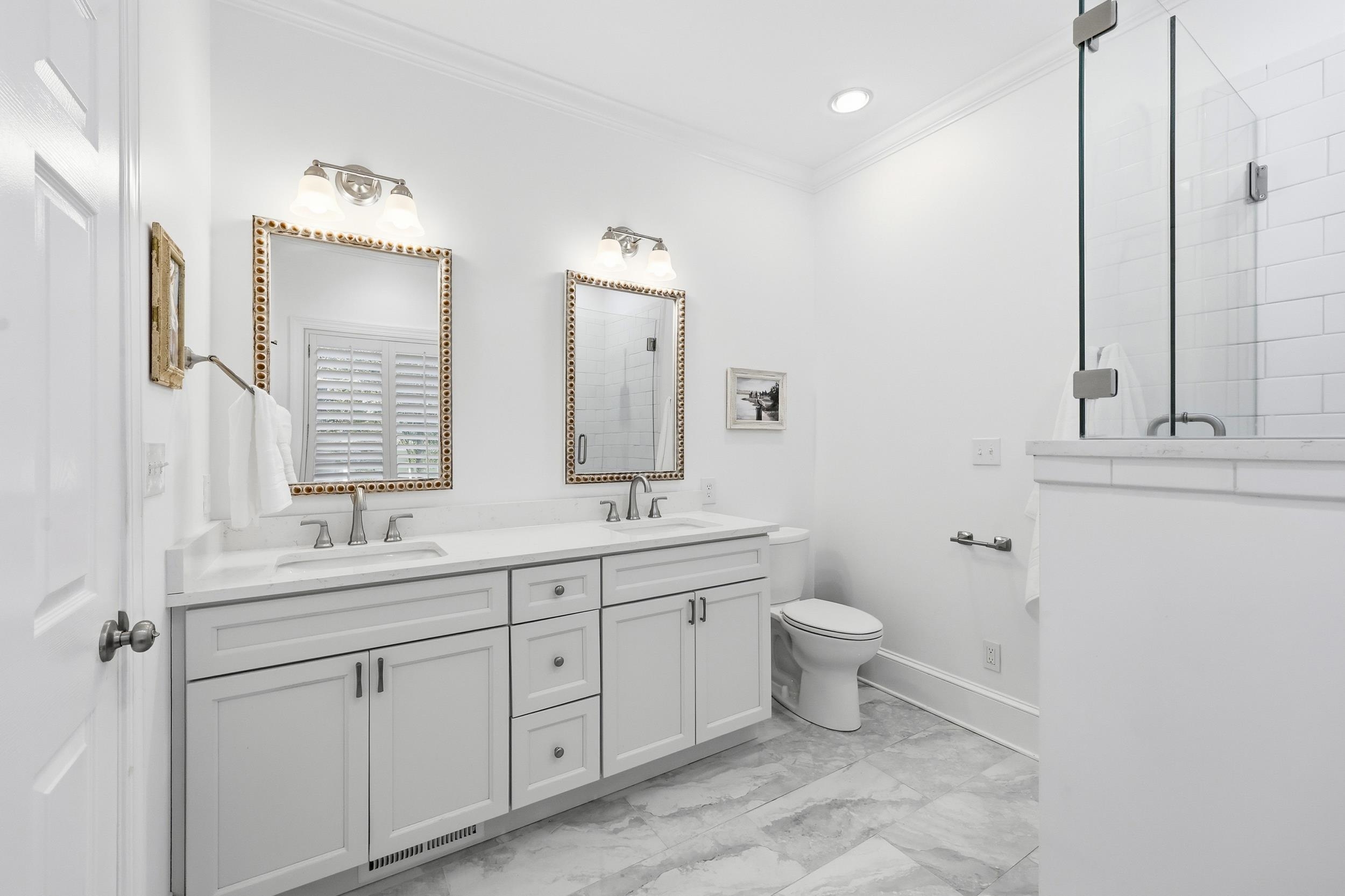 213 Old Carriage Loop Georgetown, SC 29440 - Photo 25 of 40 Bathroom featuring crown molding, double vanity, a stall shower, and light marble finish floors