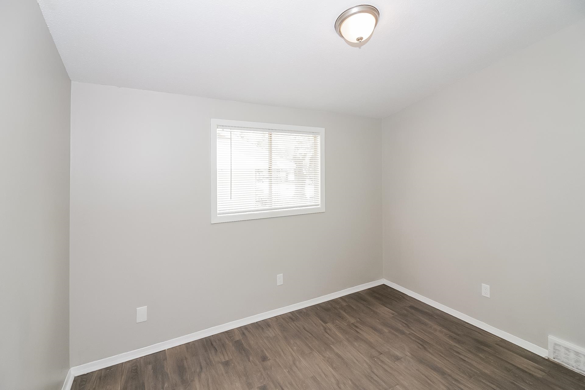 4217 Windermere Road Memphis, TN 38128 - Photo 11 of 15 an empty room with wooden floor and windows