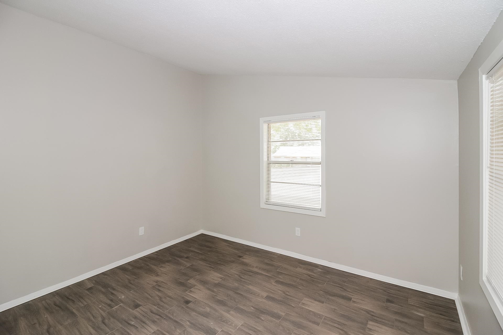 4217 Windermere Road Memphis, TN 38128 - Photo 8 of 15 an empty room with wooden floor and window