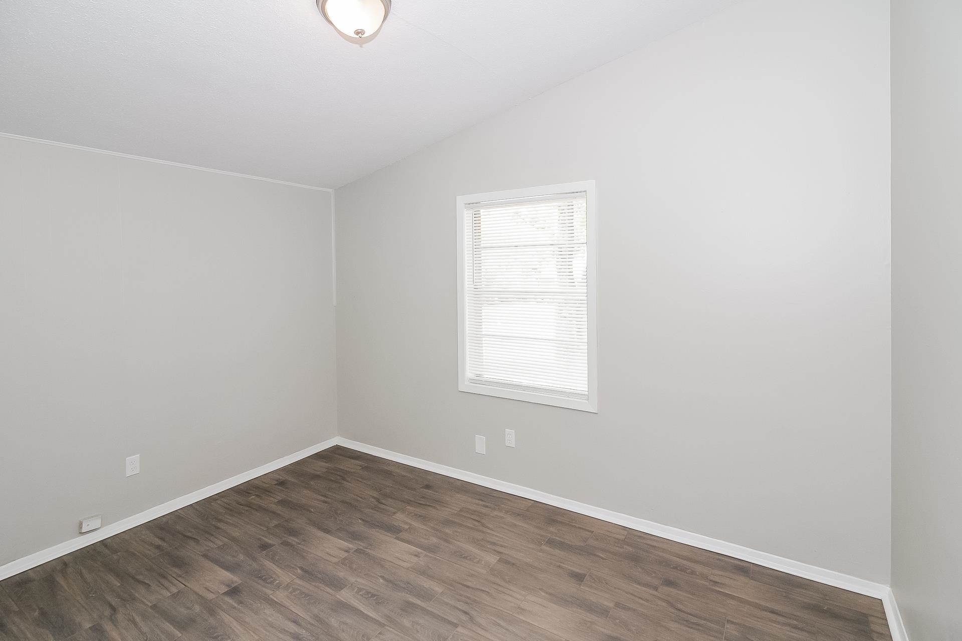 4217 Windermere Road Memphis, TN 38128 - Photo 10 of 15 an empty room with wooden floor and windows