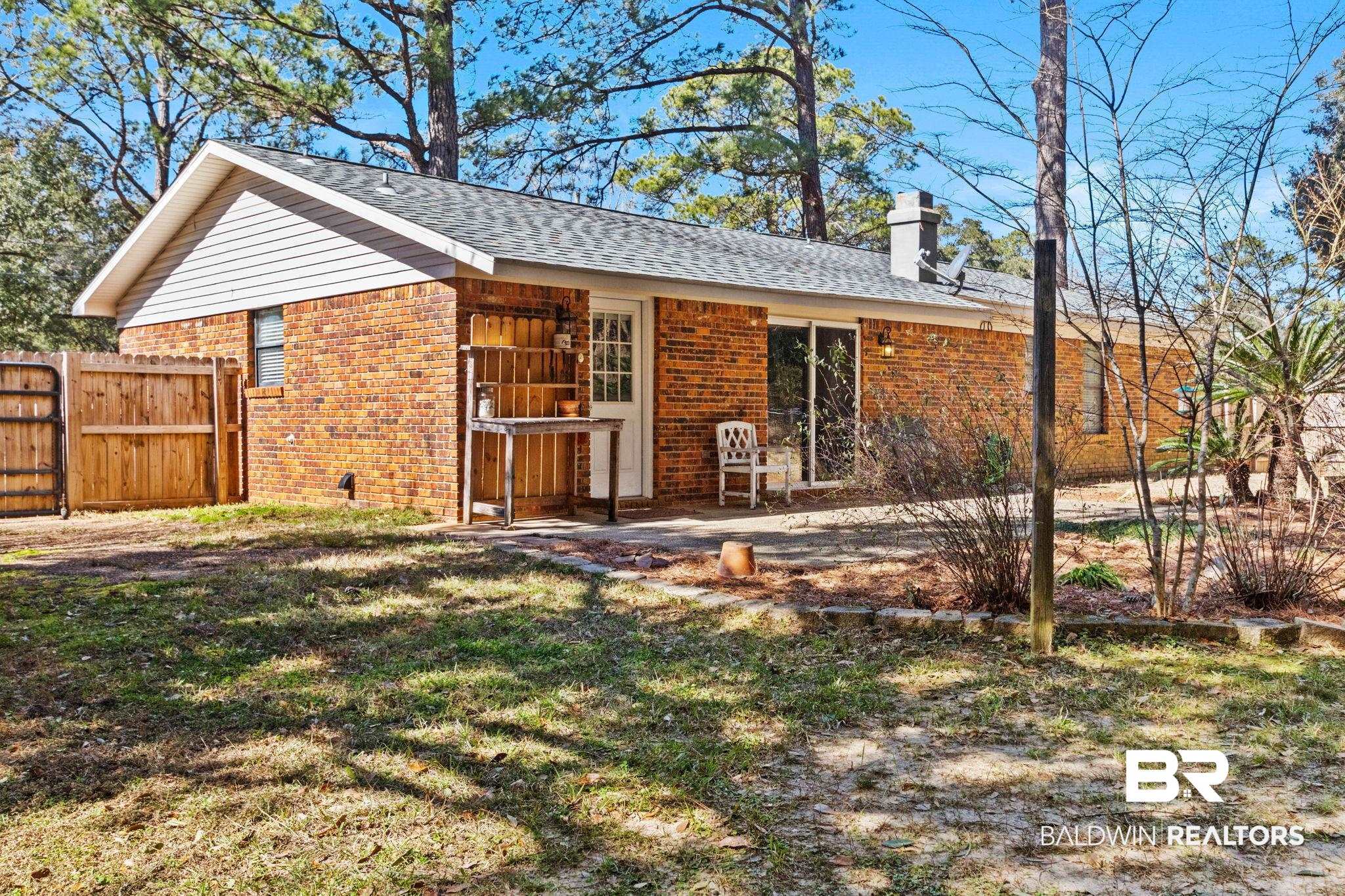 5366 Scanlan Way West Satsuma, AL 36572 - Photo 37 of 43 Rear view of house with a chimney, brick siding, a shingled roof, and a gate