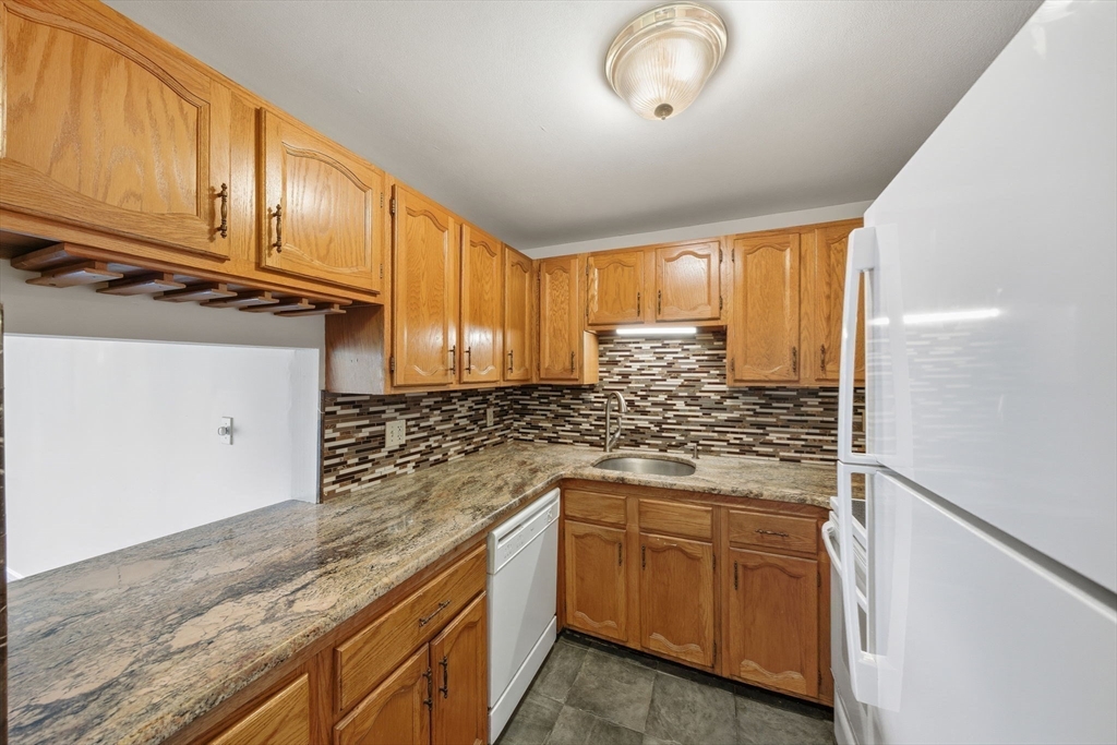 30 Conant Street, Unit 3B Beverly, MA 01915 - Photo 3 of 30 a kitchen with granite countertop wooden cabinets a sink and dishwasher