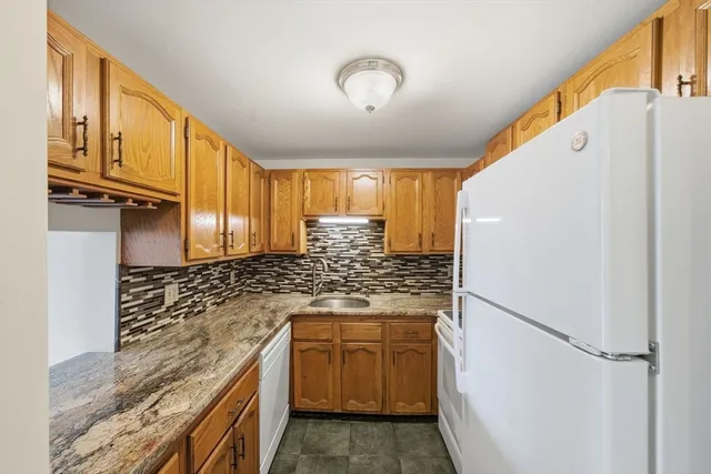 a kitchen with stainless steel appliances granite countertop a refrigerator and a stove