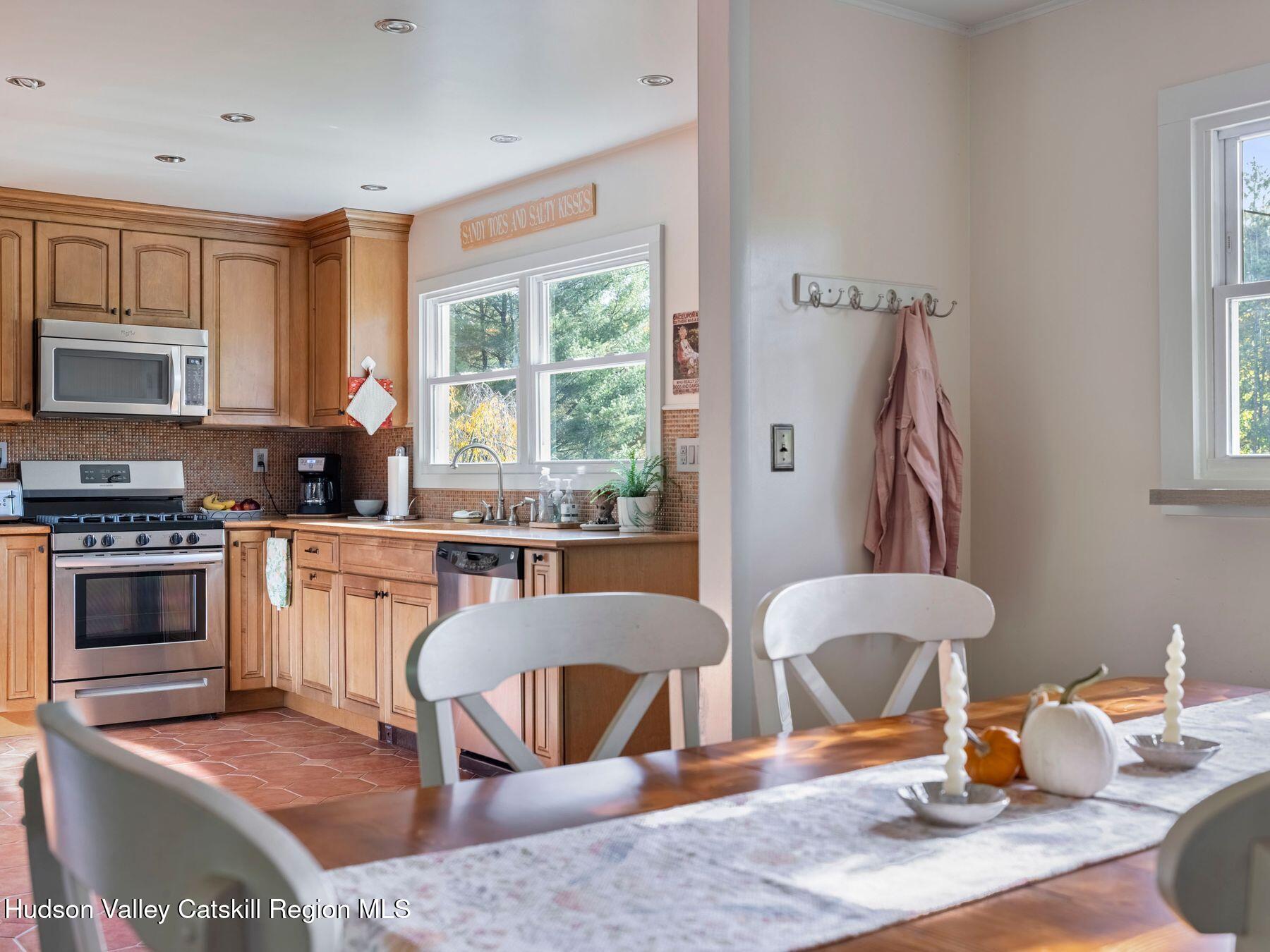 29 Hapeman Hill Road Red Hook, NY 12571 - Photo 24 of 63 a kitchen with stainless steel appliances granite countertop a stove top oven a sink a dining table and chairs with wooden floor