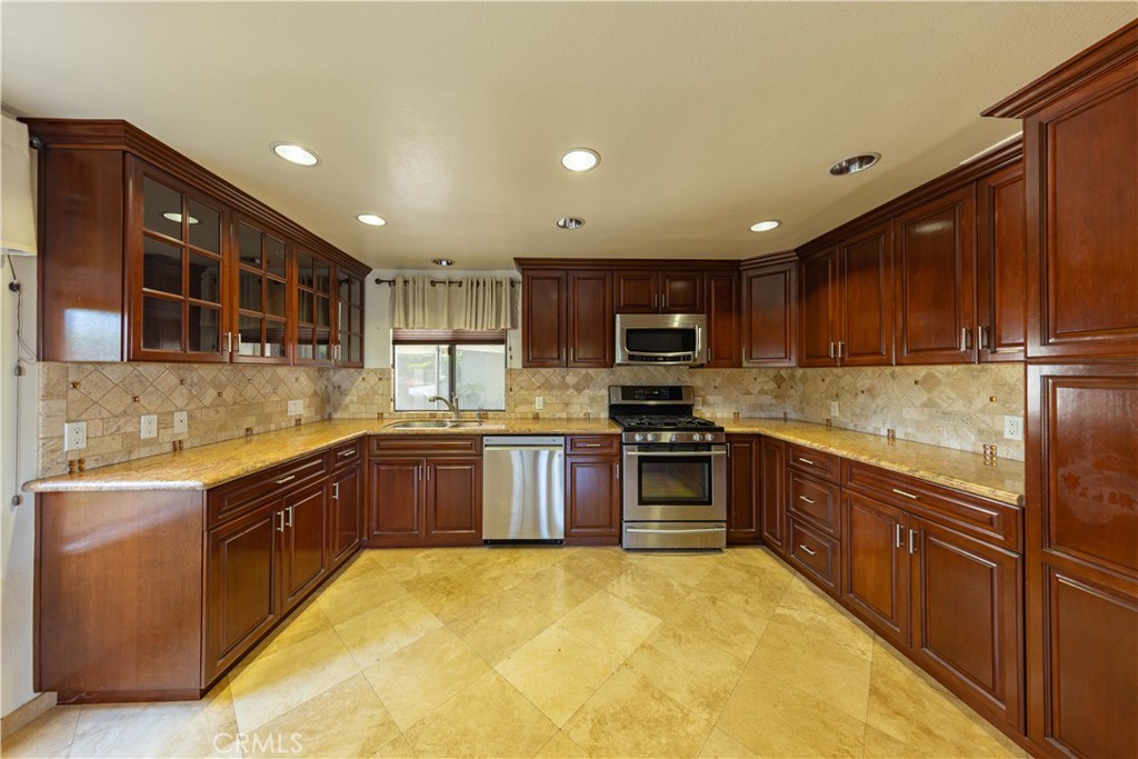 6242 Riviera Circle Long Beach, CA 90815 - Photo 7 of 29 a kitchen with stainless steel appliances granite countertop wooden cabinets a stove top oven a sink and dishwasher
