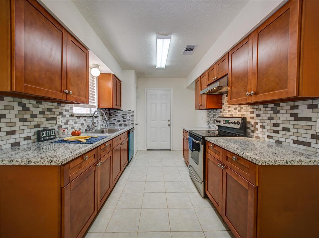a large kitchen with stainless steel appliances granite countertop a sink stove and cabinets