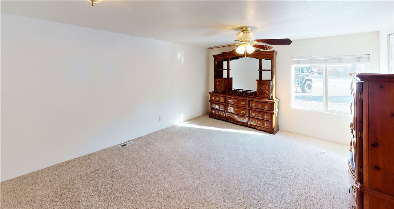 945 23 Road Grand Junction, CO 81505 - Photo 22 of 27 an empty room with chandelier fan and windows