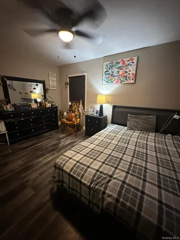 a bedroom with a bed and a flat tv screen on dresser