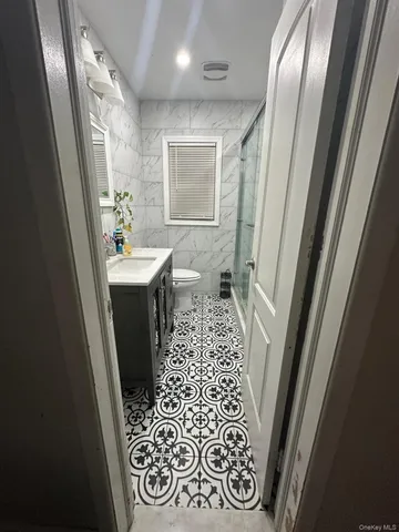 a bathroom with a sink and mirror with toilet