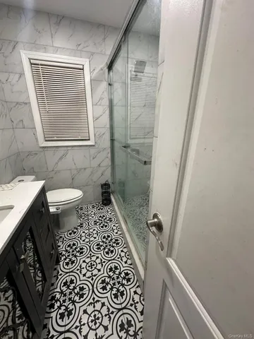 a bathroom with a sink a toilet a window and vanity