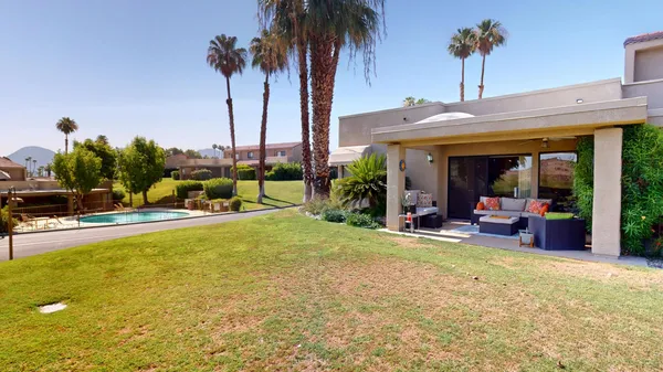 a view of a swimming pool with a lounge chair and palm trees