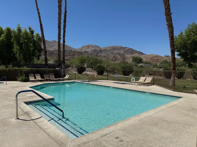 a view of a swimming pool with a patio and a yard
