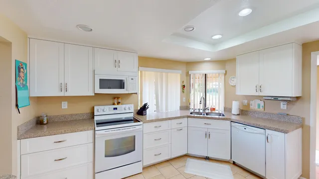 a kitchen with white cabinets sink and stainless steel appliances