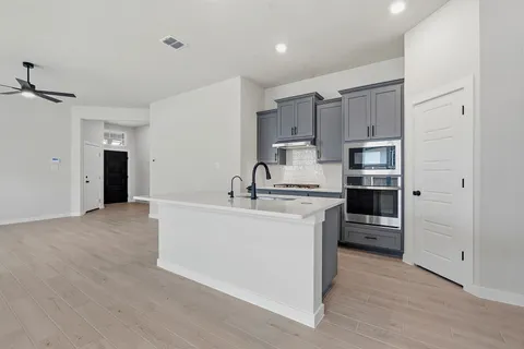 a view of kitchen with stainless steel appliances a refrigerator sink and cabinets