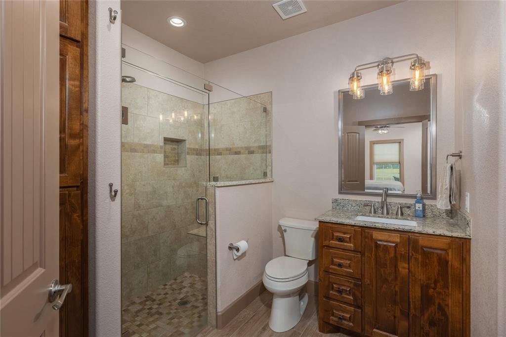 210 Spring Branch Trail North Springtown, TX 76082 - Photo 15 of 36 Bathroom featuring a glass-enclosed shower with pebble-style flooring and a tiled niche