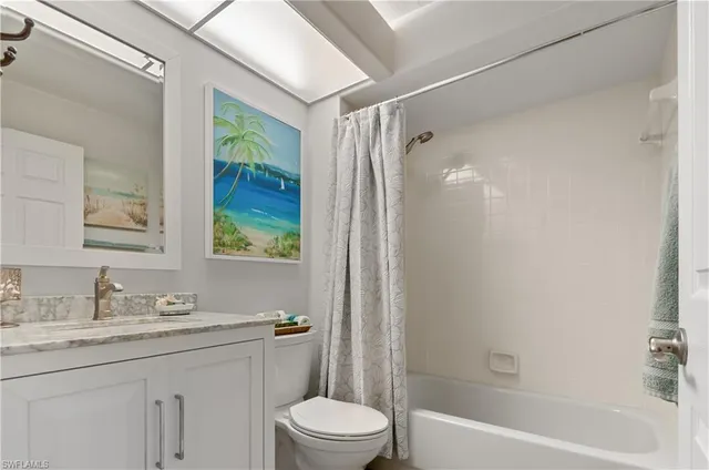 a bathroom with a granite countertop sink a toilet and shower