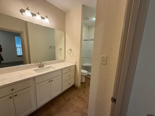 a spacious bathroom with a double vanity sink a mirror and a shower
