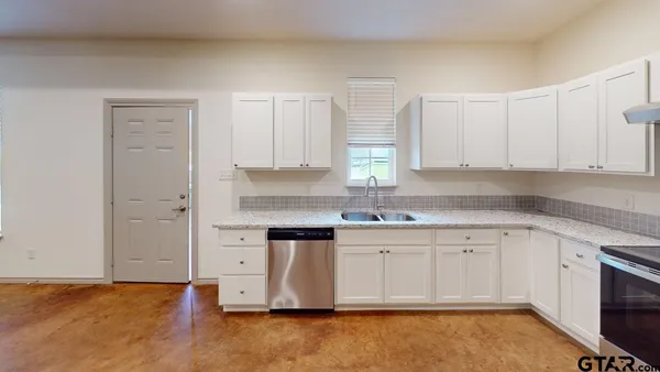 a large kitchen with stainless steel appliances granite countertop a stove a sink dishwasher and a refrigerator