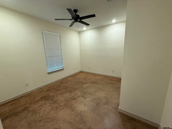 an empty room with a ceiling fan and a window