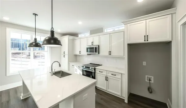 a kitchen with stainless steel appliances a stove a sink a refrigerator a center island and cabinets
