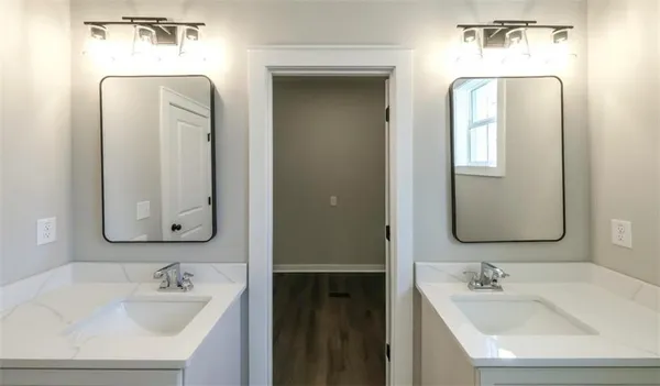 a bathroom with double vanity sinks and a mirror