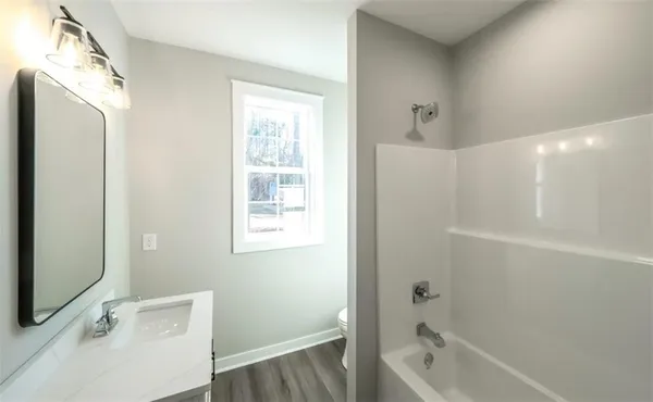 a bathroom with a tub a sink and a large mirror