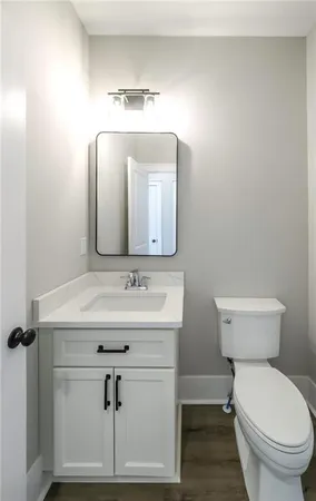 a bathroom with a toilet a sink and mirror