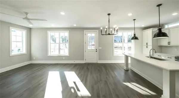 a kitchen with stainless steel appliances granite countertop wooden floors sink and window