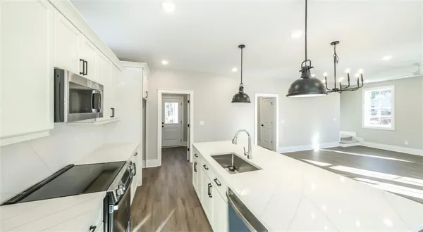 a kitchen with stainless steel appliances kitchen island granite countertop a sink and a granite counter tops