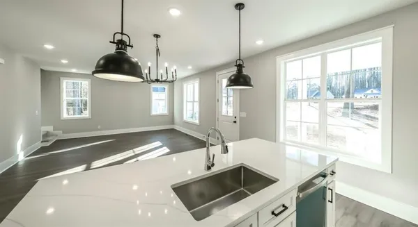 a kitchen with a sink a counter top space and a chandelier