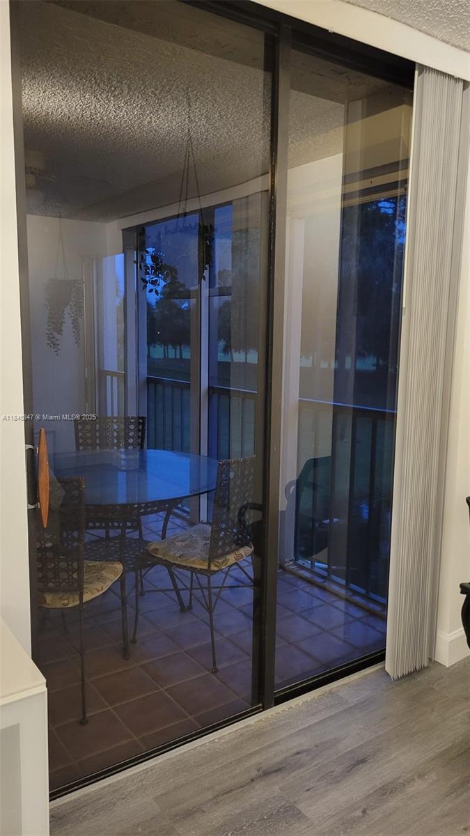 6562 Boca Del Mar Drive, Unit 225 Boca Raton, FL 33433 - Photo 22 of 24 a view of a hallway with wooden floor and a table in it