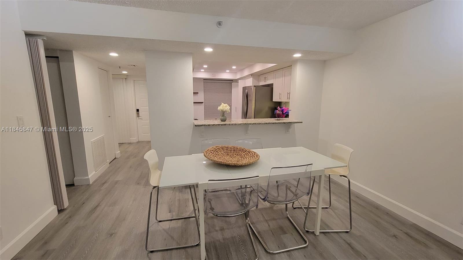 6562 Boca Del Mar Drive, Unit 225 Boca Raton, FL 33433 - Photo 6 of 24 a kitchen with stainless steel appliances a table and chairs in it