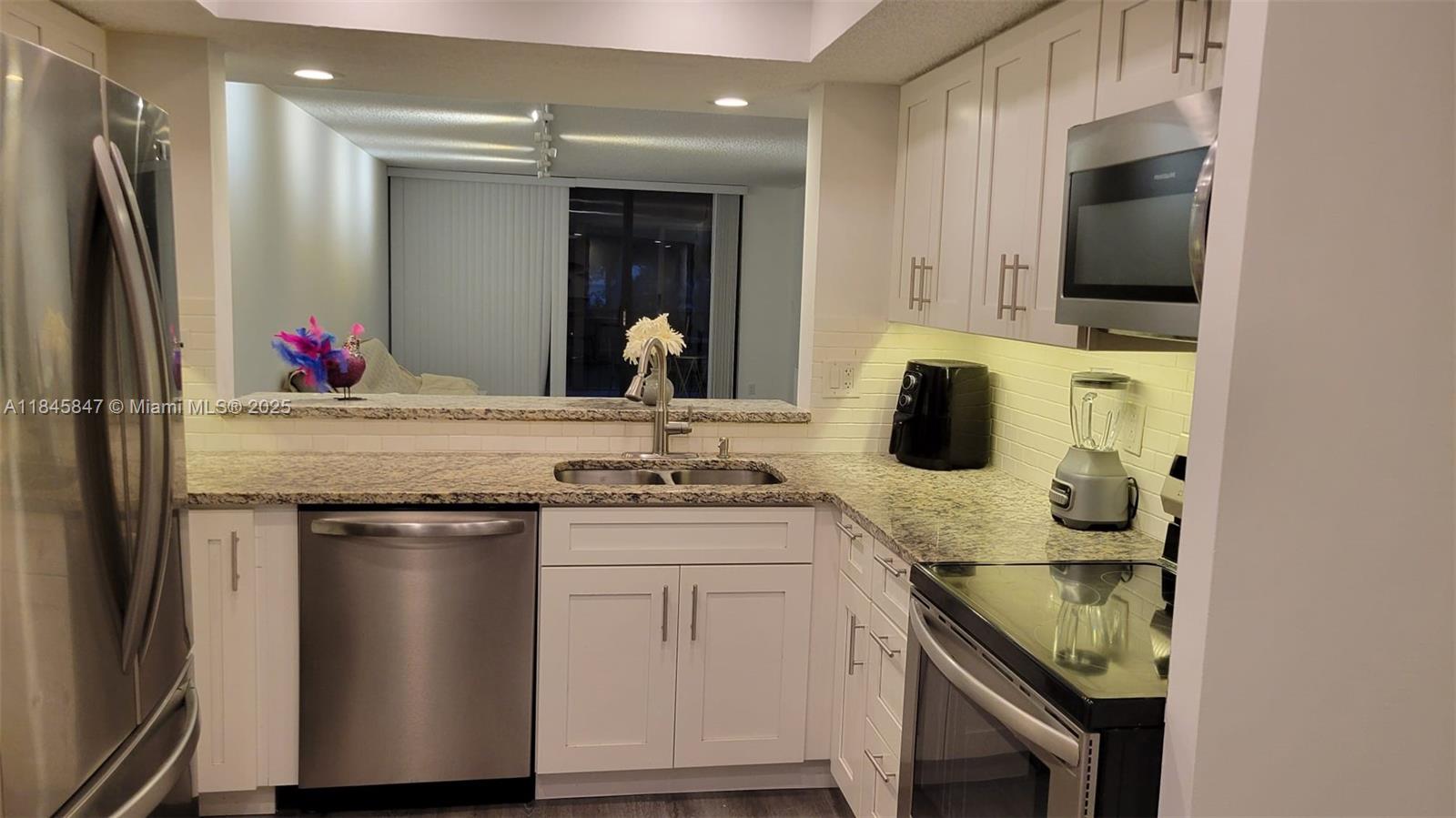 6562 Boca Del Mar Drive, Unit 225 Boca Raton, FL 33433 - Photo 9 of 24 a kitchen with a sink stove and refrigerator