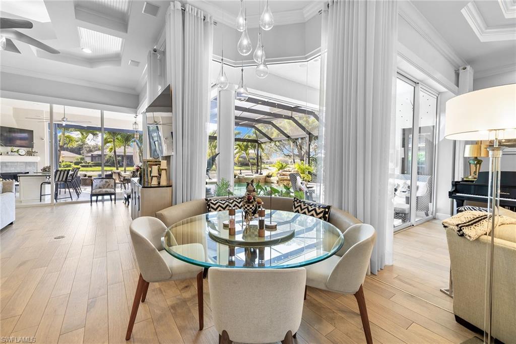 7837 Classics Drive Naples, FL 34113 - Photo 14 of 50 Dining room with crown molding, coffered ceiling, light wood-style flooring, and a sunroom