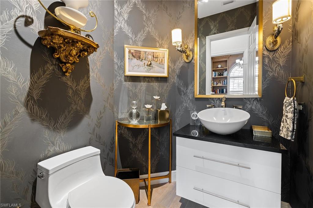 7837 Classics Drive Naples, FL 34113 - Photo 27 of 50 Half bathroom with vanity and wallpapered walls