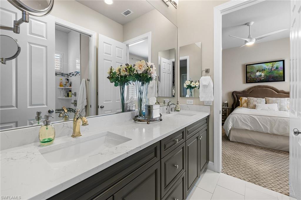 7837 Classics Drive Naples, FL 34113 - Photo 29 of 50 Bathroom with double vanity, light carpet, a ceiling fan, connected bathroom, and light tile patterned floors