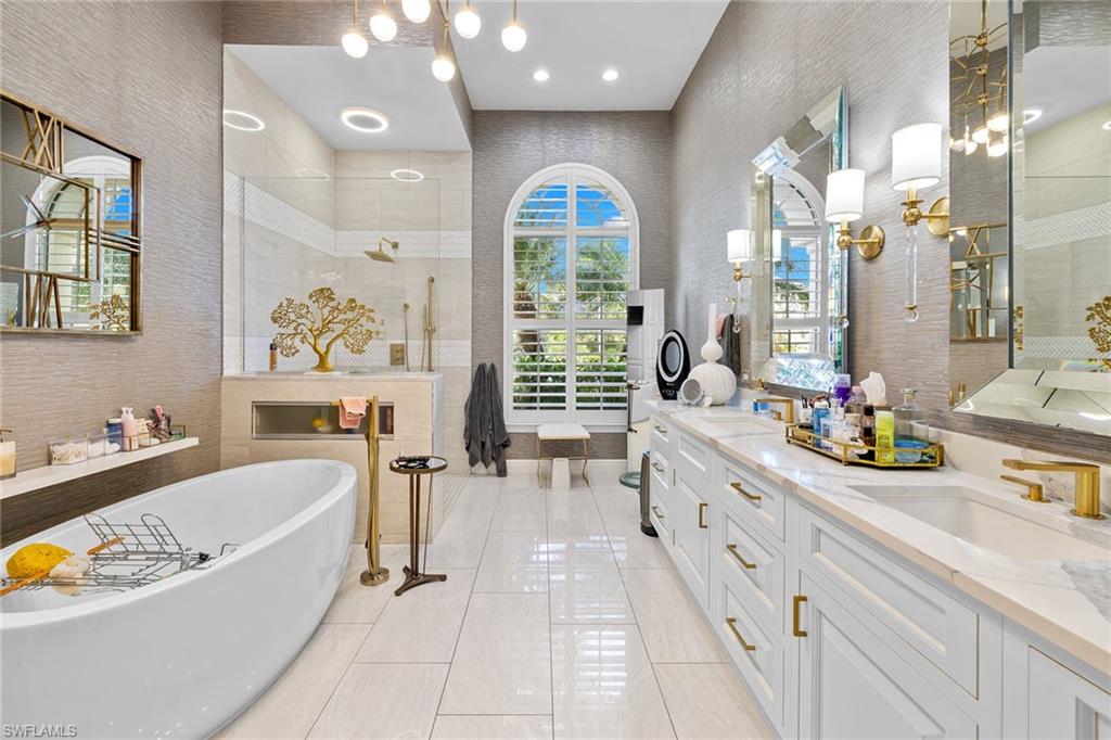 7837 Classics Drive Naples, FL 34113 - Photo 35 of 50 Full bathroom featuring a soaking tub, double vanity, a walk in shower, a chandelier, and recessed lighting