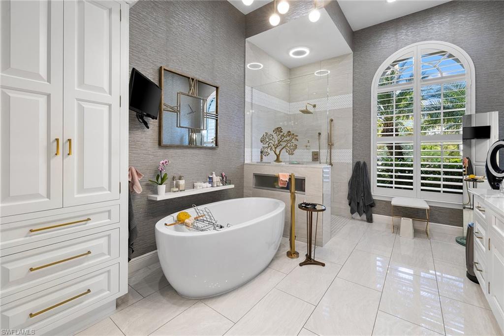 7837 Classics Drive Naples, FL 34113 - Photo 36 of 50 Bathroom featuring walk in shower, a freestanding tub, vanity, and light tile patterned flooring