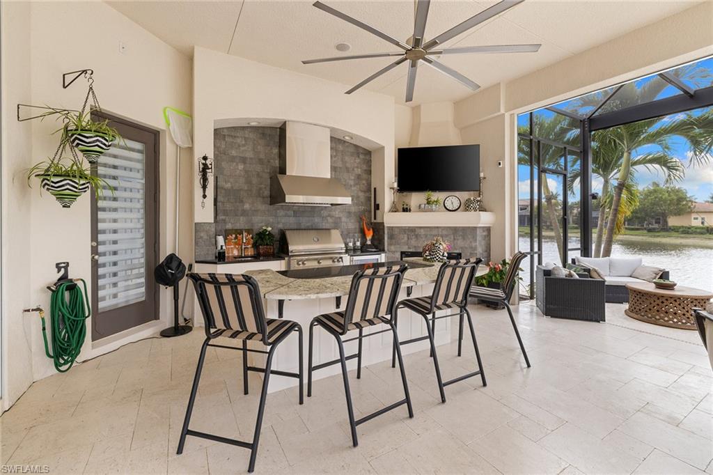 7837 Classics Drive Naples, FL 34113 - Photo 39 of 50 View of patio / terrace with exterior kitchen, glass enclosure, ceiling fan, a sunroom, and an outdoor hangout area