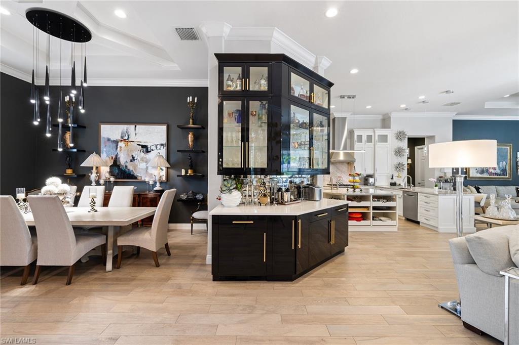 7837 Classics Drive Naples, FL 34113 - Photo 48 of 50 Kitchen with open floor plan, pendant lighting, recessed lighting, light stone counters, and light wood-style flooring