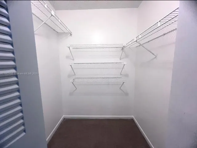 a view of walk in closet with empty racks