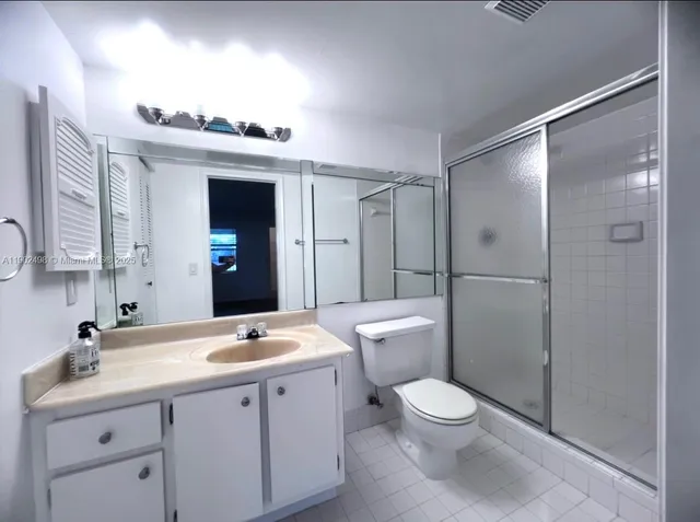 a bathroom with a toilet a sink a mirror and a shower