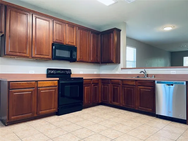 a kitchen with granite countertop wooden cabinets and a stove top oven