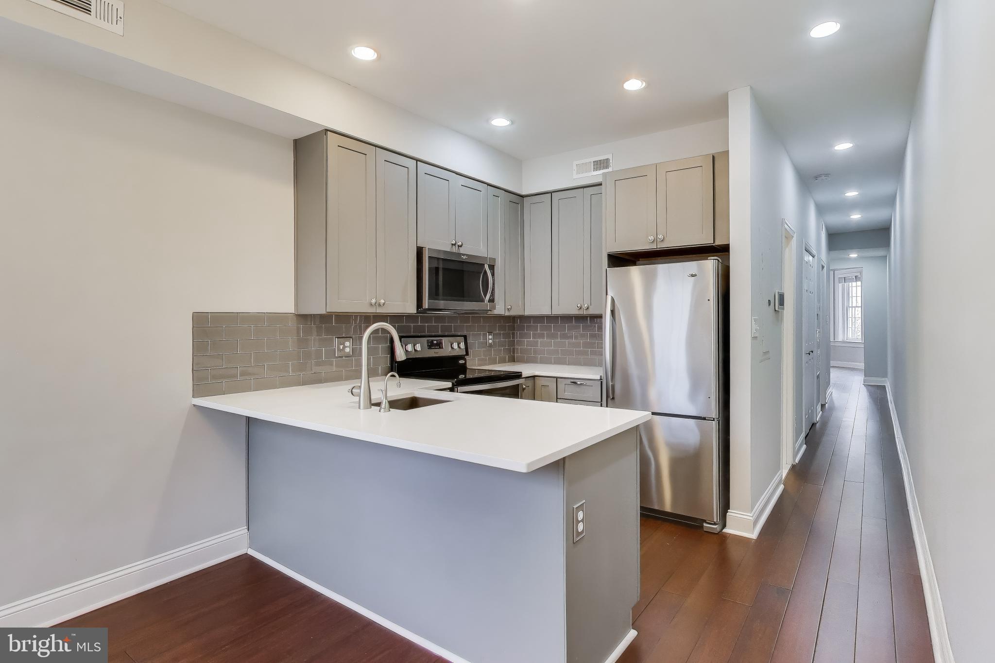 1724 21st Street Northwest, Unit 3 Washington, DC 20009 - Photo 4 of 17 a kitchen with refrigerator cabinets and wooden floor