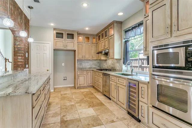 a kitchen with stainless steel appliances granite countertop a stove a sink and a microwave