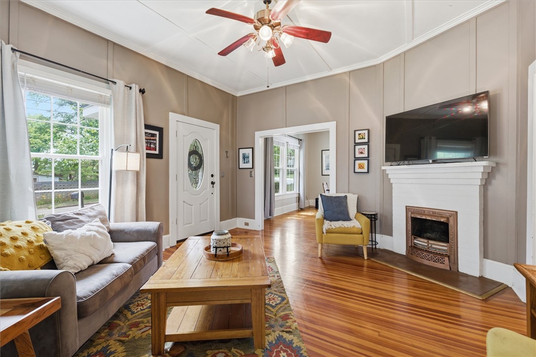 1104 Power Street Anderson, SC 29621 - Photo 4 of 34 Rich hardwood floors complement this cozy living space, centered around a charming fireplace with ornate detailing.