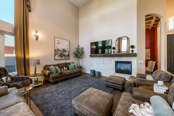 a living room with furniture and floor to ceiling windows